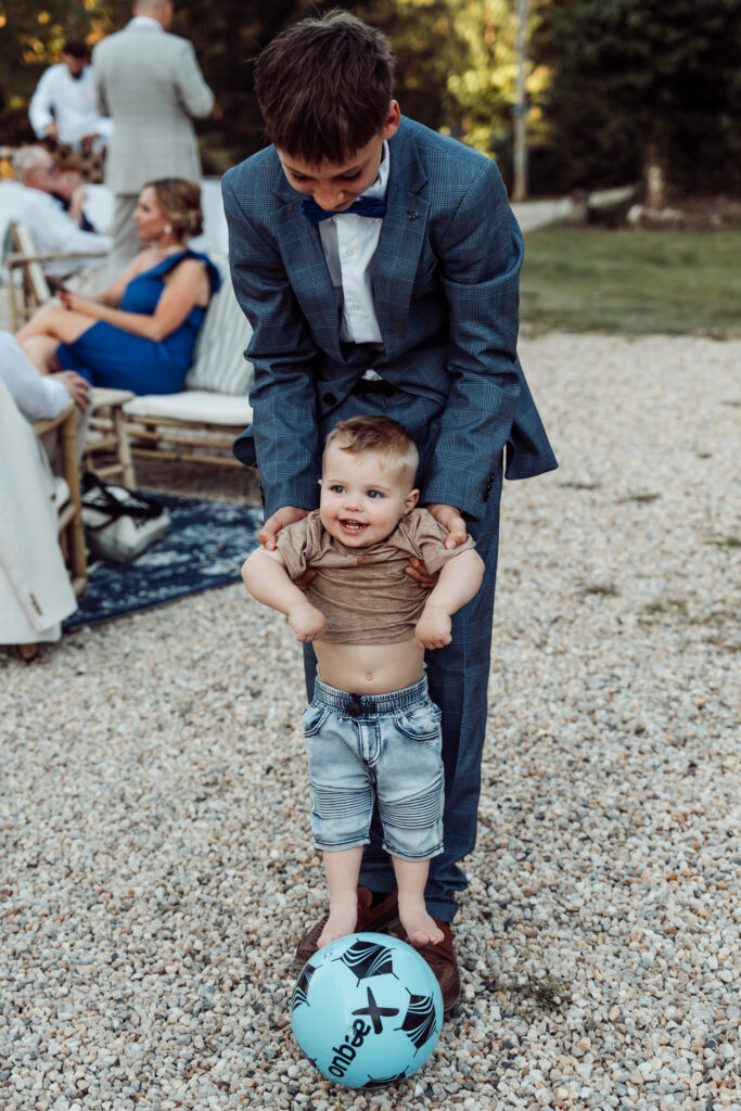 Child lifting a smiling toddler just above the ground.