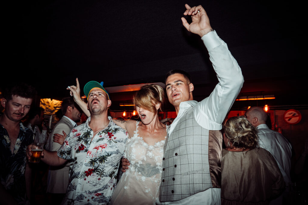 Guests dancing outdoors at night during the wedding celebration.