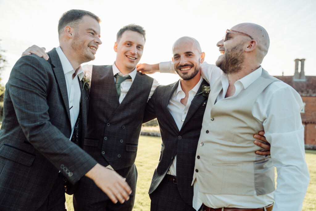 Groomsmen with their arms around each other smiling.