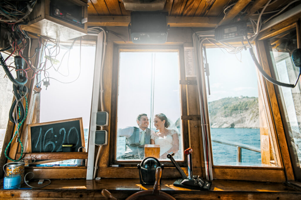 Couple smiling through a boat window during a destination wedding photography session in Croatia.