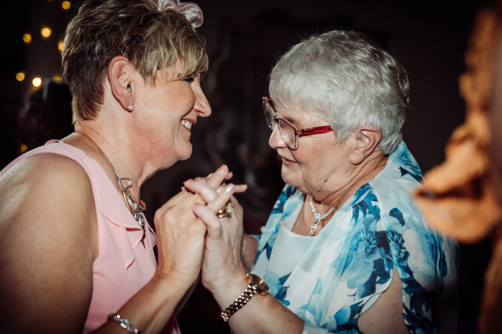 Wedding guests smiling while dancing.