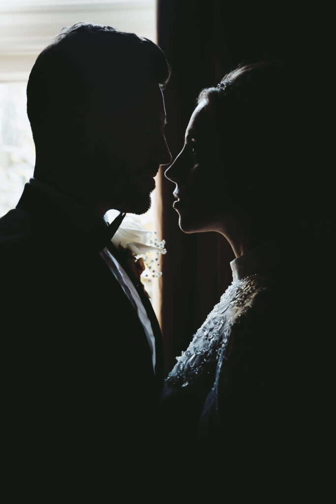 silhouette picture of the wedding couple facing each other.
