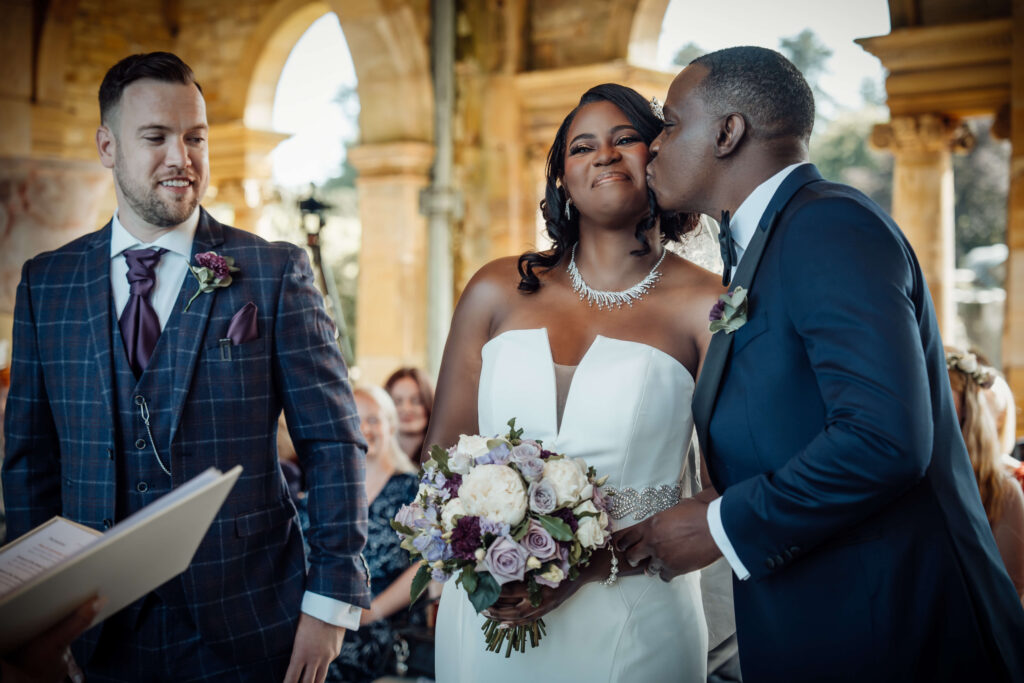 Bride and her father sharing a kiss on the cheek at the front of the ceremony.