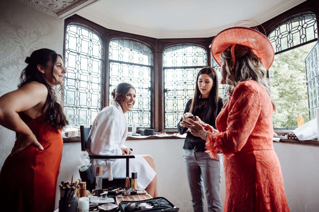 Bridal party chatting while the bride gets her makeup done.