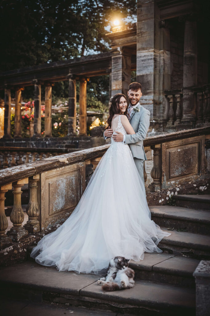 Bride and groom embracing on the steps of the Hever Castle Loggia.