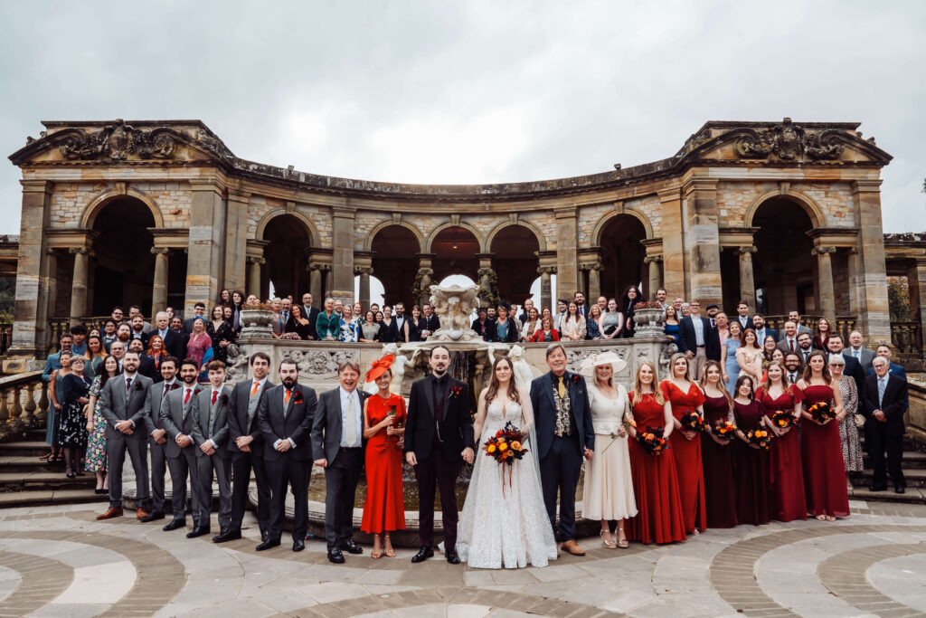 Traditional group photo of the wedding party at the Hever Castle Loggia.