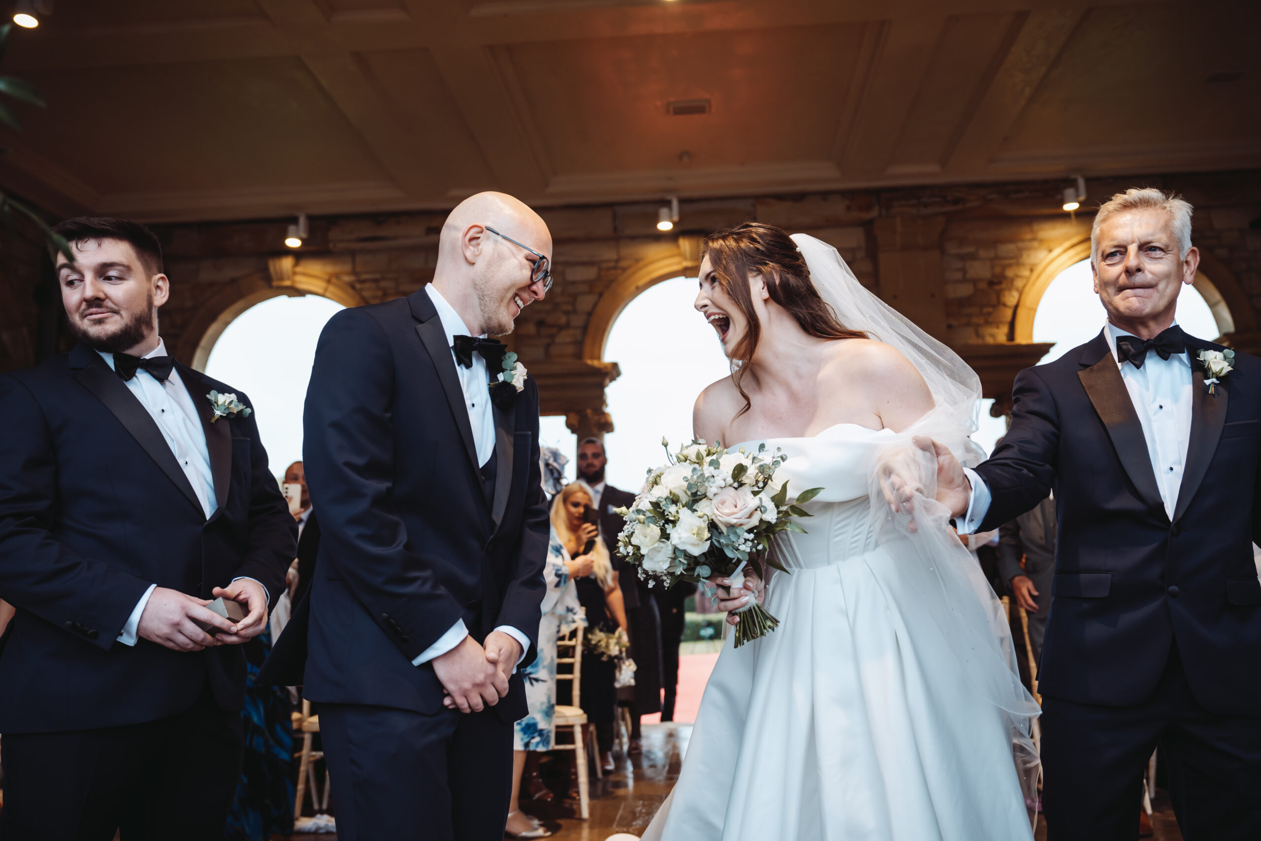 a couple meeting for the first time that day down the isle at the italian loggia at their hever castle wedding ceremony.