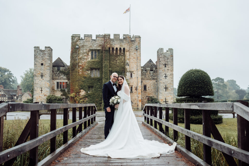 Couple standing on a bridge with a majestic castle behind, captured by Luxury Wedding Photographer in Kent, Teri V Photography