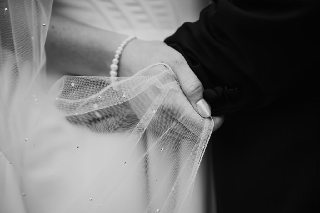 Close-up of hands holding a delicate veil, captured by Luxury Wedding Photographer in Kent, Teri V Photography.