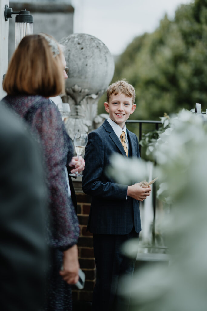 Candid photo of a young boy smiling during the wedding, captured by a luxury wedding photographer