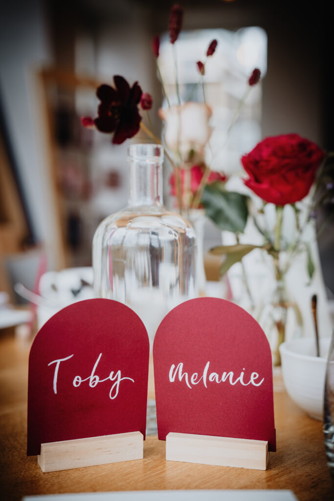 Wedding table decor with red roses and personalised place cards at The Swan London. 