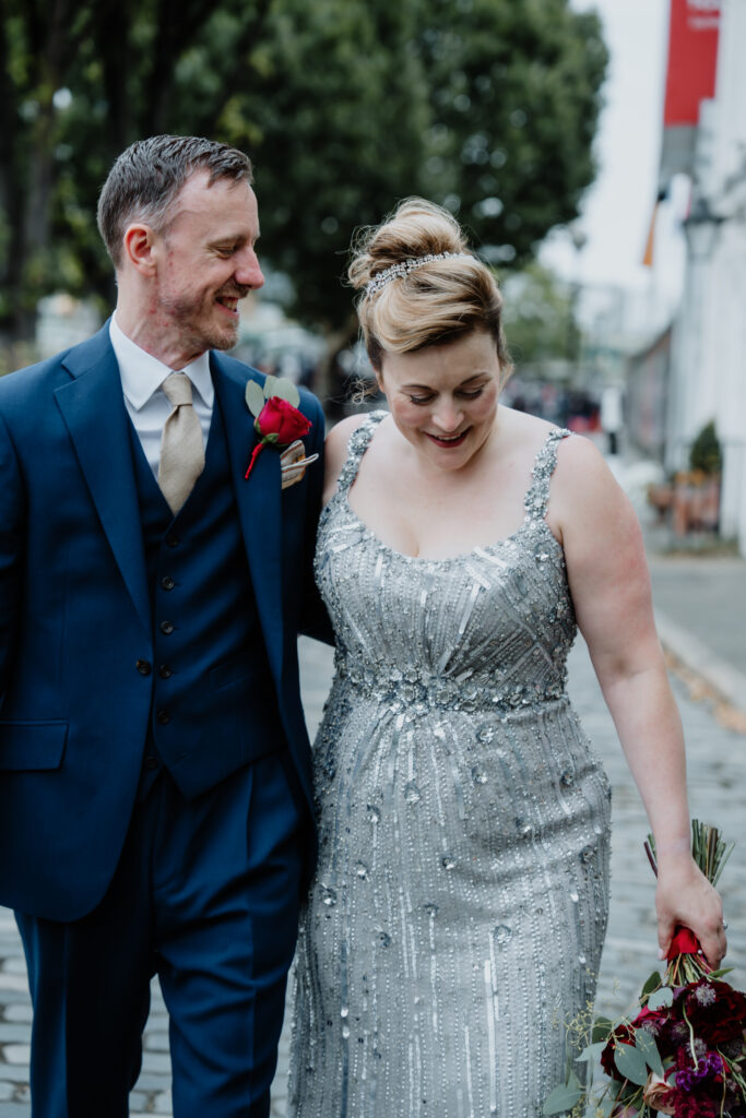 happy couple walking along the London Thames during a private wedding photography session. Captured by a UK luxury wedding photographer
