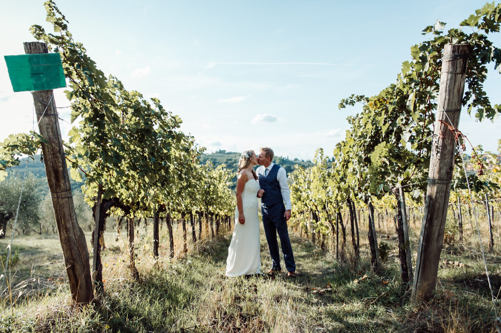 Couple sharing a kiss among the vineyards, photographed by a Castello di Cafaggio Wedding Photographer
