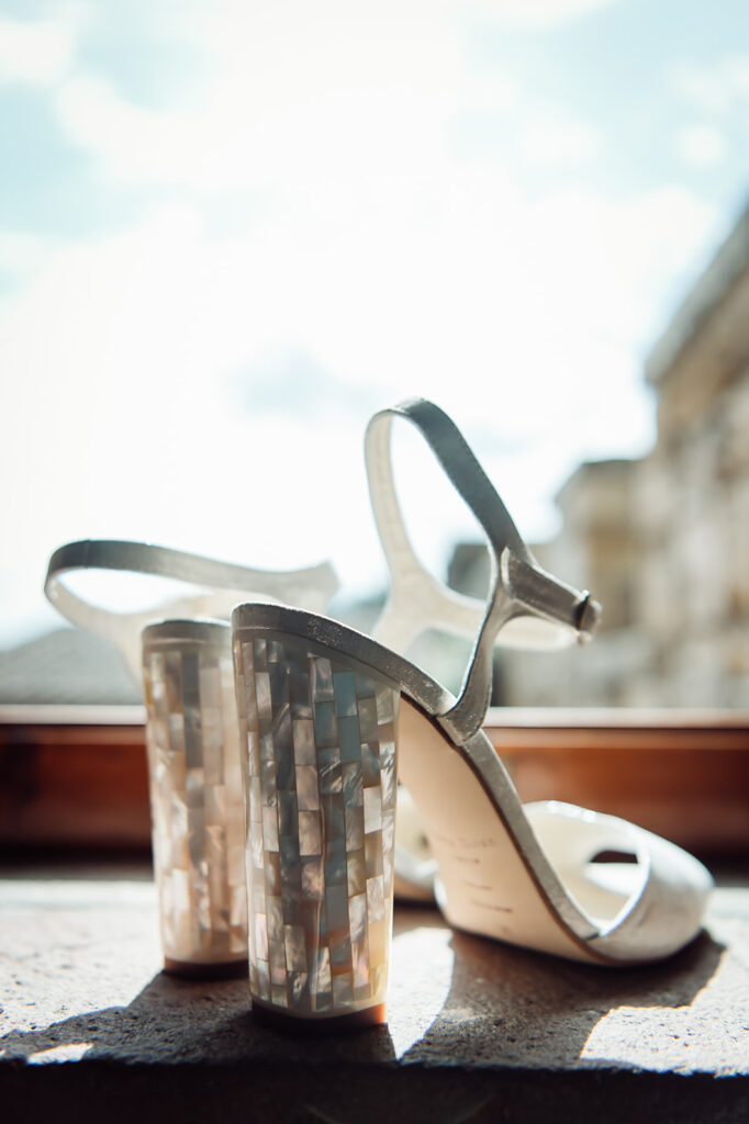 Bride’s wedding heels sitting by a sunlit window at a Tuscan castle wedding