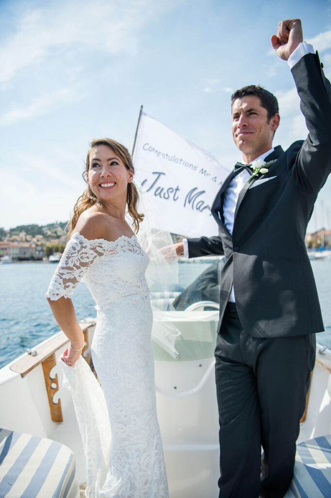 Wedding photo of a couple standing on a boat, enjoying the moment.
