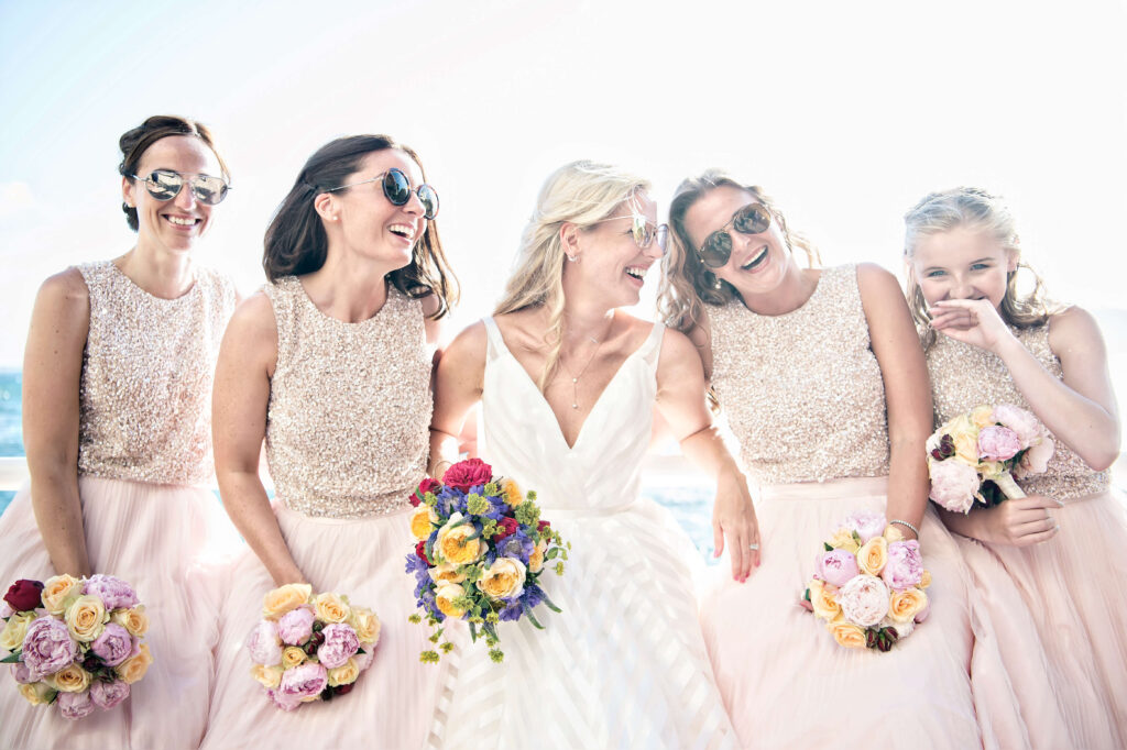 Bride and bridesmaids laughing together for a photo.