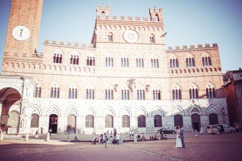 Wide shot of the the big wedding venue with the couple at the bottom kissing.