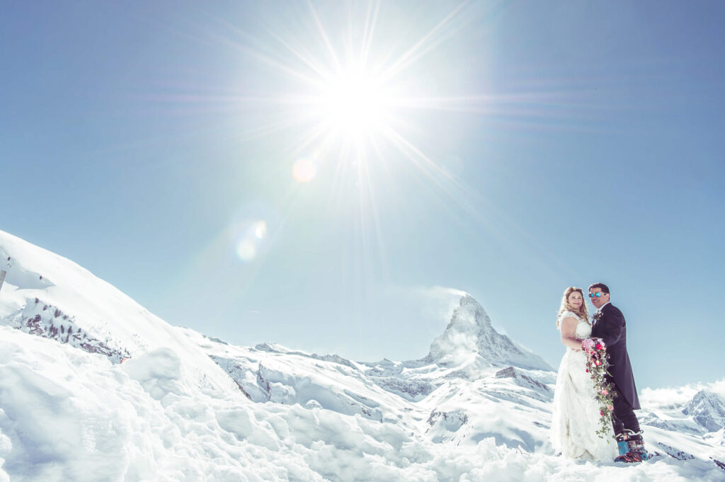 couple embracing on a snowy mountain during a destination wedding photoshoot