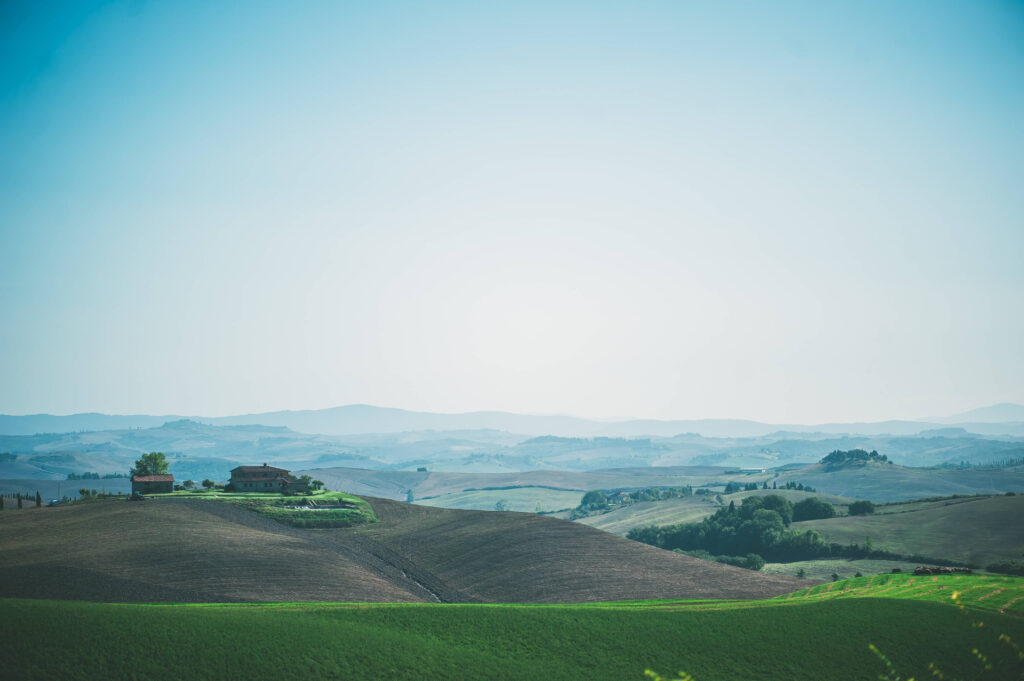 Landscape of rolling green hills under a clear, light blue sky, perfect for a scenic destination wedding backdrop