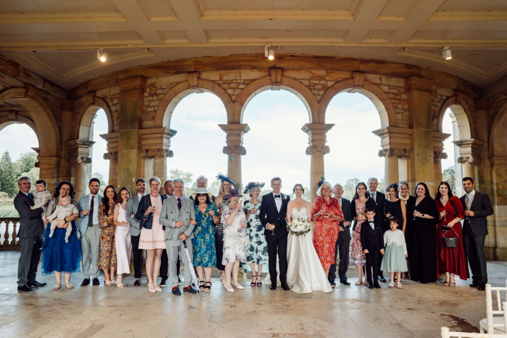 A formal shot of the wedding party facing the camera. This is located at the Loggia, at Hever Castle. [Teri V Photography Wedding Timeline Guide]