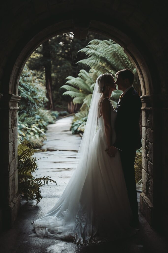 Couple in a close embrace under a round archway at Hever Castle