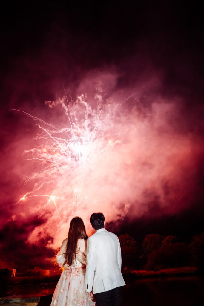 Wedding couple watching fireworks at Hever Castle, photographed by a Hever Castle wedding photographer.
